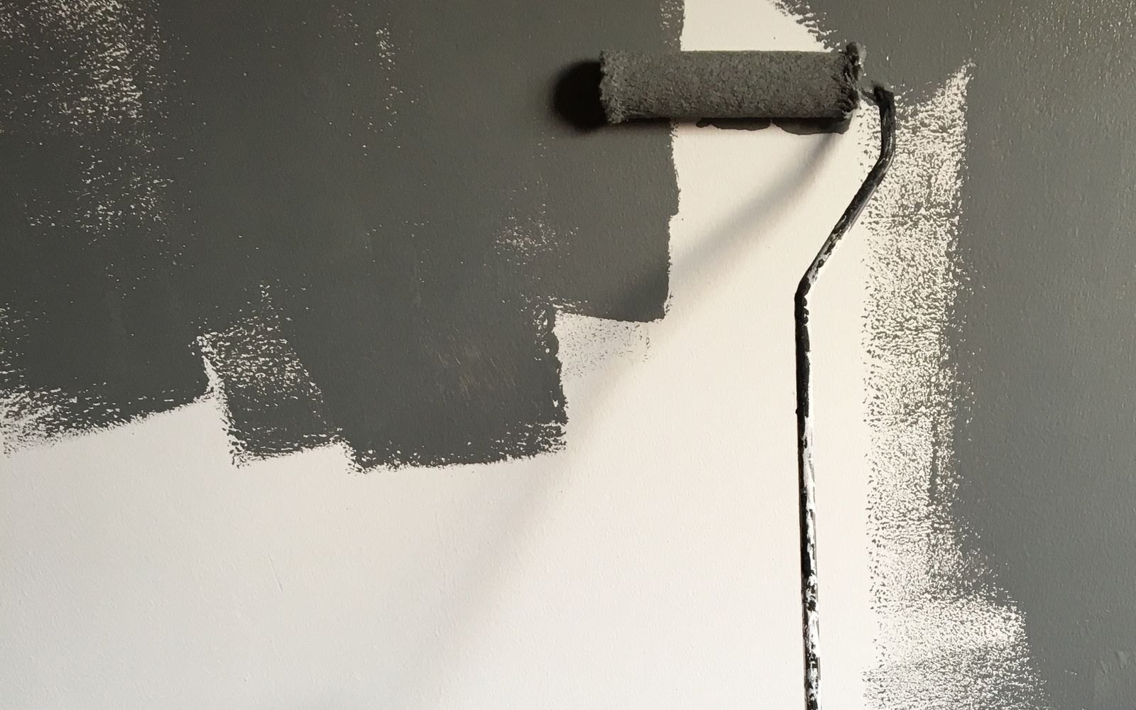 Paint roller mid-stroke on a wall